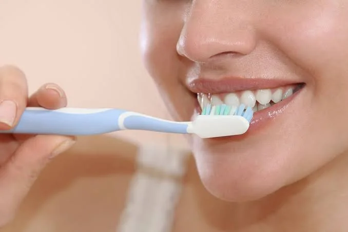 Woman brushing her teeth with a soft toothbrush