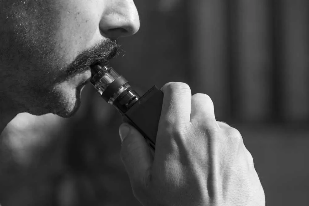 Man using a vape, in black and white